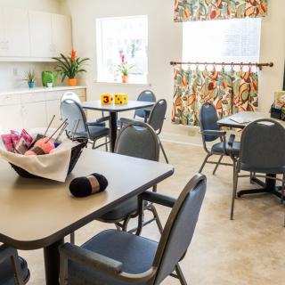 A well-lit dining room with several tables and chairs, featuring colorful decorations.
