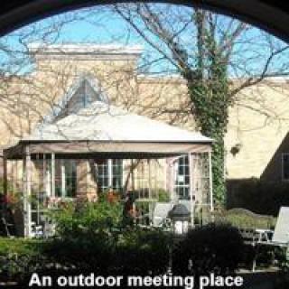 A cozy outdoor meeting place with a gazebo and garden furniture.