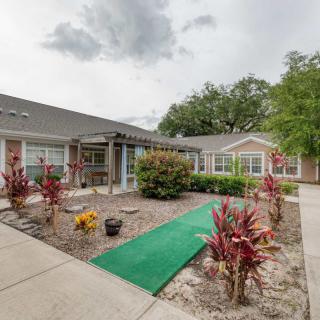 A well-maintained garden area with a green pathway leading to a building.