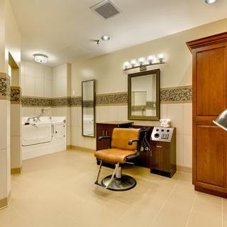 A modern salon interior featuring a barber chair, mirror, and ample lighting.