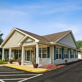 A small office building with a paved parking area in front.