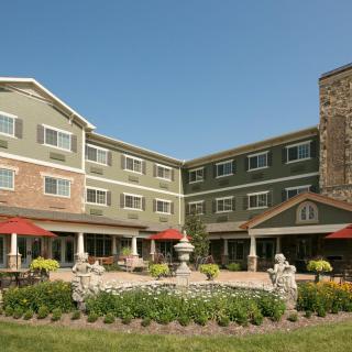 A well-maintained hotel with a landscaped garden and outdoor seating area.