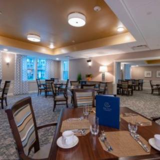 A cozy and elegant dining room with neatly set tables and warm lighting.
