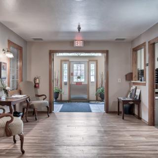 A warmly lit lobby area with comfortable seating and wooden flooring.