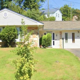 A suburban house with a spacious lawn and driveway.