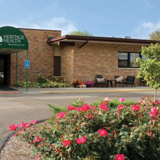 A welcoming entrance to a facility surrounded by vibrant flowers.