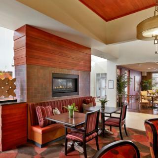 A modern hotel lobby with a cozy seating area and fireplace.