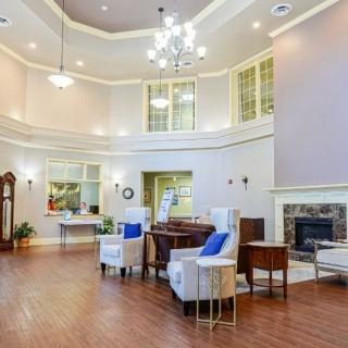 A spacious, elegantly designed living room with a chandelier and fireplace.