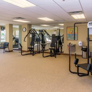 A clean and spacious gym with various exercise machines.