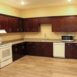 A modern kitchen with wooden cabinets and essential appliances.