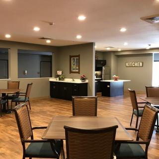 A view of a modern seating area with tables and chairs, featuring warm lighting and a welcoming atmosphere.