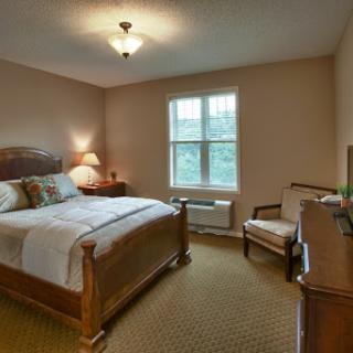 A cozy and welcoming bedroom with warm tones and natural light.