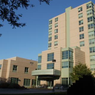 A modern hospital building under a clear blue sky.