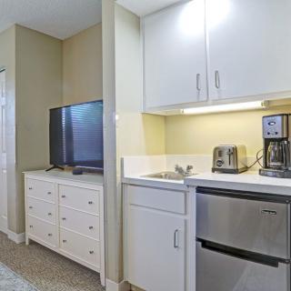 A modern kitchenette with a TV and appliances.