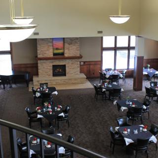 A spacious dining area with elegantly set tables and a cozy fireplace.