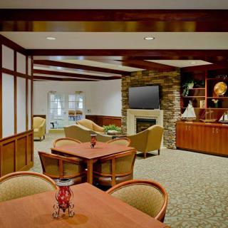 A cozy lounge area featuring comfortable seating, a fireplace, and a television.