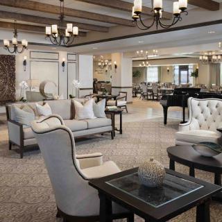 An elegantly designed living room featuring luxurious furniture and chandeliers.