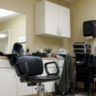 A barbershop interior featuring a barber chair, mirror, and various hair styling tools.