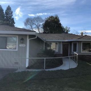 A suburban house with a well-maintained front yard and clear blue sky.