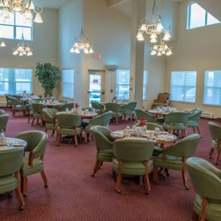 A well-lit dining area with multiple tables and chairs arranged neatly.