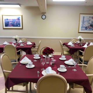A beautifully arranged dining area featuring tables set with elegant dishware and decorative flowers.