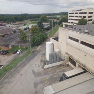 A view of an industrial area showcasing buildings and a road lined with power poles.