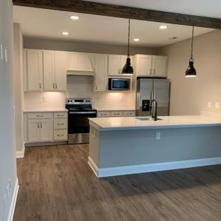 A modern open-concept kitchen with pendant lighting and stainless steel appliances.