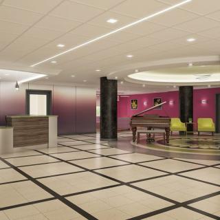 A spacious and modern lobby featuring a piano and a reception desk.