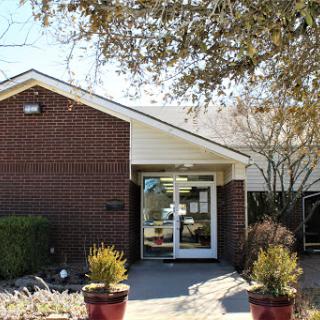 A welcoming entrance to a brick building, surrounded by potted plants.