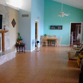 Spacious living and dining area with a ceiling fan and hardwood flooring.