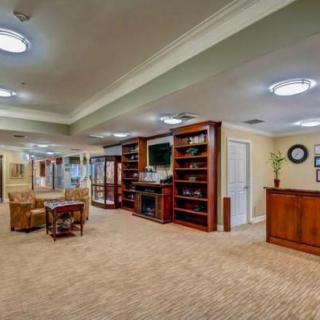A spacious living room interior with bookshelves, a TV, and comfortable seating.