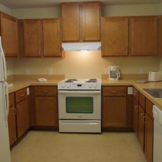 A modern kitchen with wooden cabinets and standard appliances.