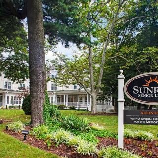 A scenic view of a building with a sign and lush greenery.