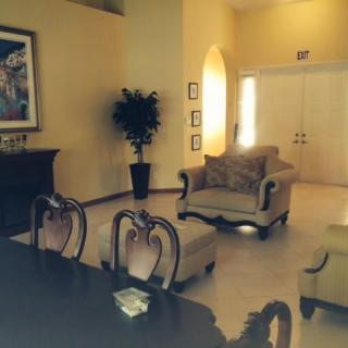 A cozy and elegantly furnished living room with armchairs, a sofa, a table, and decorative elements.