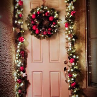 A beautifully decorated door for the holiday season, adorned with a wreath and festive garlands.