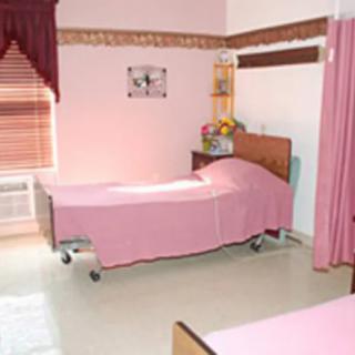 A hospital room with neatly arranged beds and pink dcor.