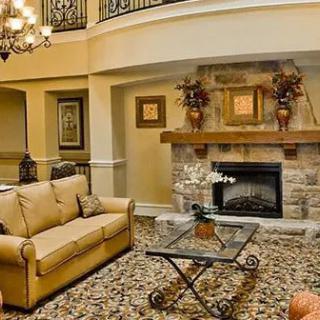 A cozy and elegant living room with a stone fireplace and classic decor.