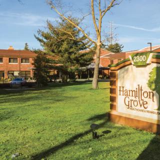 A view of a building with a sign reading 'Hamilton Grove' on a sunny day.