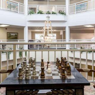 A spacious lobby with a large chess set and elegant chandelier.