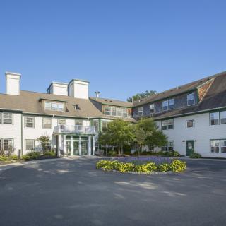 A view of a hotel building with a clear blue sky and surrounding greenery.