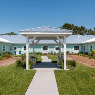 A single-story building with a manicured lawn and clear blue sky.