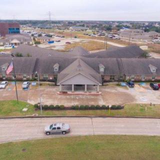Aerial view of a suburban building with a parking lot and surrounding area.