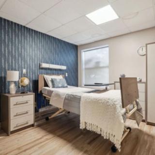 A modern hospital room with a single patient bed and stylish decor.
