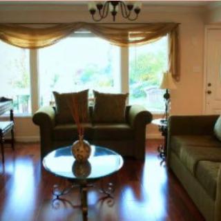 A cozy living room with elegant furniture and a large window providing natural light.