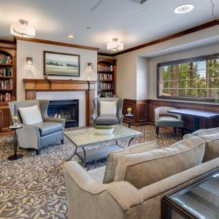 A cozy living room featuring a fireplace, elegant furniture, and built-in bookshelves.