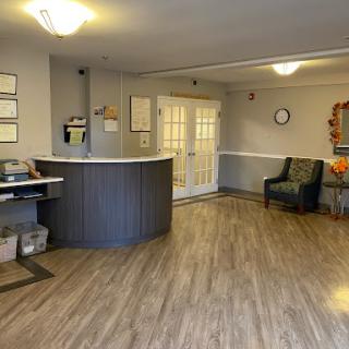 A welcoming reception area featuring a desk, comfortable seating, and natural light.