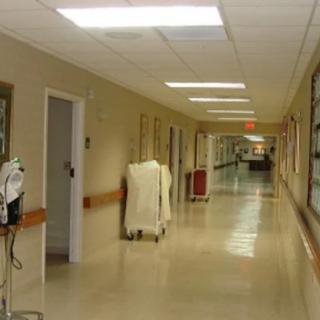 A quiet hospital corridor with medical equipment along the walls.