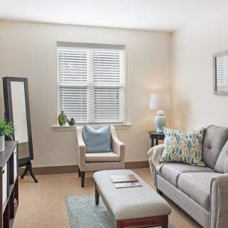 A cozy, well-decorated living room with a sofa, armchair, and various home decor accents.