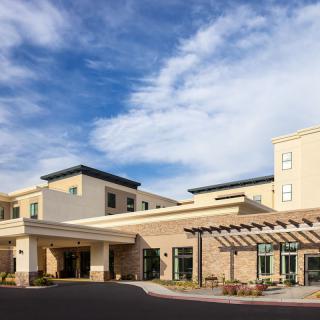 Modern hospital building under a clear blue sky.