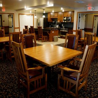 A cozy dining area with wooden tables and chairs, featuring a warm interior design.
